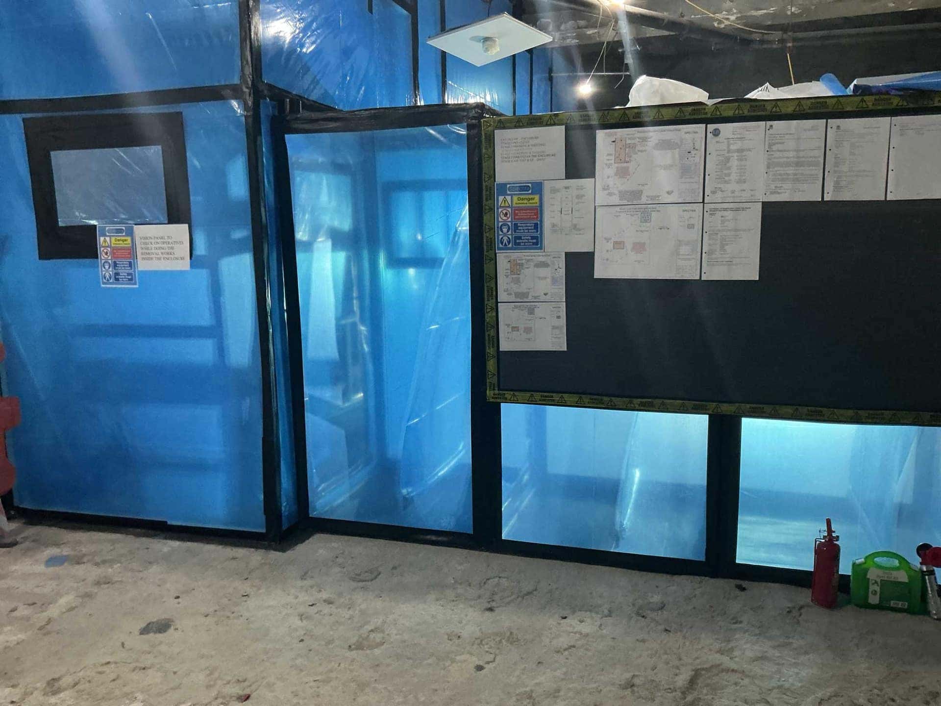 Sealed asbestos enclosure with vision panel and site documentation