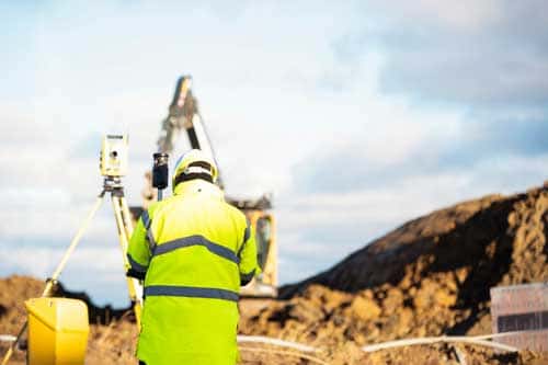 Site engineer setting out levels on a cleared site