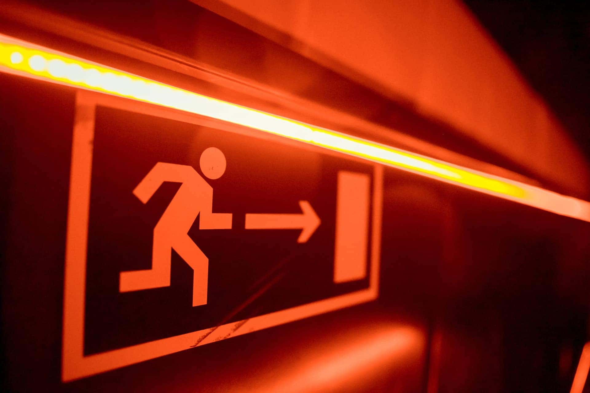 Illuminated emergency exit sign above a corridor